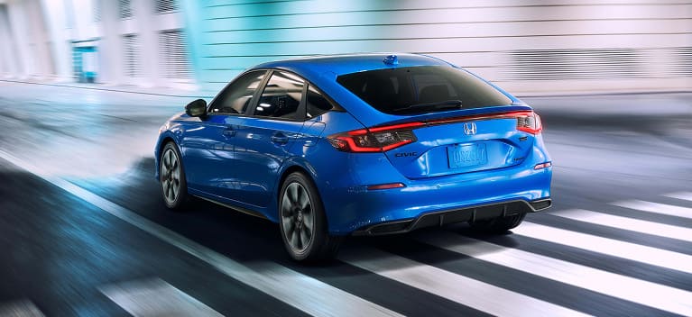 2026 Honda Civic Hatchback Sport Touring Hybrid in Boost Blue Pearl back driving through a tunnel (Compact Hatchback).