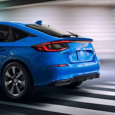 2026 Honda Civic Hatchback tSport Touring Hybrid in Boost Blue Pearl back driving through a tunnel (Compact Hatchback).