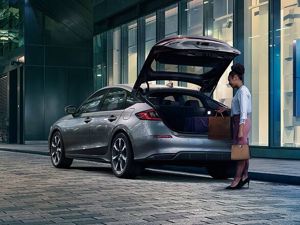 2026 Honda Civic Hatchback Sport Touring Hybrid in Solar Silver Metallic back parked on a city street with the hatch open (Compact Hatchback).